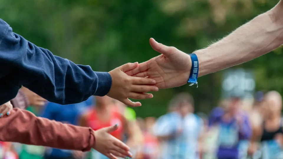High five on the run - one adult hand and a child's hand. Photo. 