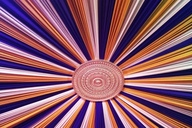 Three fabrics in three different colours are gathered in the middle with an ornamented button. Photo.