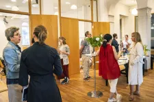 People mingling and talking indoors. Photo.